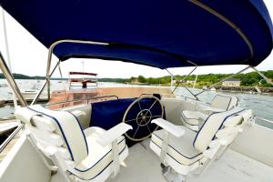 ein Boot mit weißen Sitzen auf dem Wasser in der Unterkunft Maine Bed & Boat, Nebi in Damariscotta