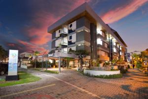 a building on a street in a city at night at Xênius Hotel in João Pessoa
