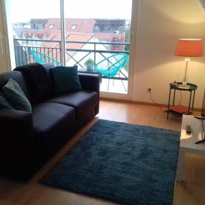 a living room with a couch and a large window at Balcon avec vue panoramique de la mer, le village et la campagne - parking privé in Wimereux