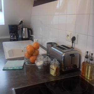 a kitchen counter with a toaster and oranges on it at Balcon avec vue panoramique de la mer, le village et la campagne - parking privé in Wimereux