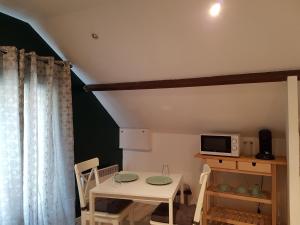 a dining room with a table and a microwave at Palaiseau - proche Orly et Paris in Palaiseau