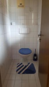 a bathroom with a toilet with a blue seat and towels at Gästehaus Eberl - Rita in Finkenberg