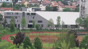 ein Gebäude in einer Stadt mit einem Baseballfeld in der Unterkunft Apartments R Sport boutique in Sarajevo