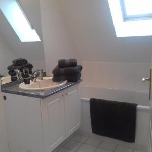 a bathroom with a sink and a bath tub at Balcon avec vue panoramique de la mer, le village et la campagne - parking privé in Wimereux
