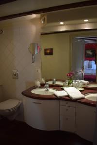 een badkamer met een wastafel, een toilet en een spiegel bij Aurora in Schiedam