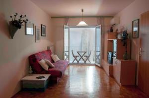 a living room with a red couch and a balcony at Spacious balcony apartment Piran in Piran