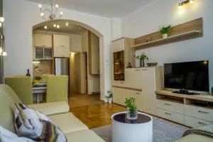 a living room with a couch and a tv and a kitchen at Yellow Bike Apartment in Zagreb