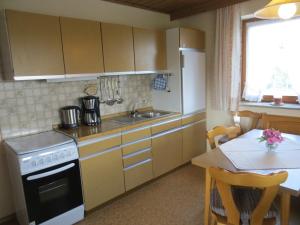 a kitchen with a sink and a stove and a table at Haus Spiessl in Bad Griesbach