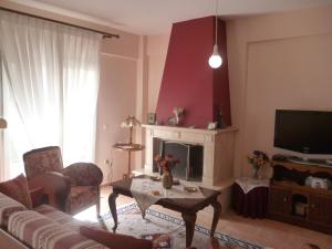 a living room with a couch and a table and a tv at Dream House in Iraklitsa