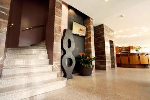 a lobby with a spiral staircase in a building at Hotel Corso Alaxi Hotels in Alassio