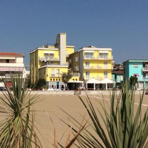 a group of buildings on a beach with a building at Hotel Verona in Caorle