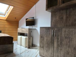 a bedroom with wooden walls and a tv on a wall at EC Hotel Elchingen in Elchingen