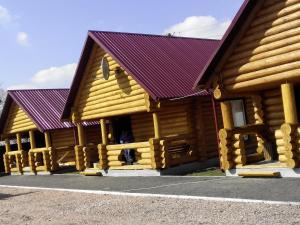 dos cabañas de madera con techo púrpura en Гостевой дом Фестивальный, en Kiev