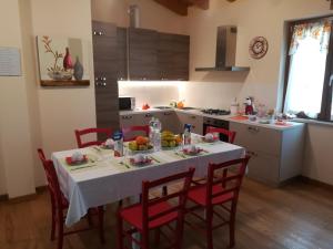 una cocina con una mesa blanca con sillas rojas en Corte Ohana, en Monteforte dʼAlpone