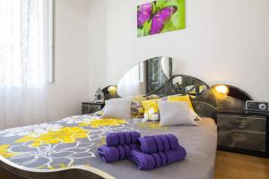 a bedroom with a large bed with purple and yellow pillows at Apartment Stefania on the beach in Koromačno