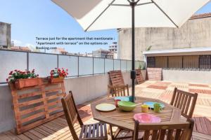 einen Holztisch mit Stühlen und einem Sonnenschirm auf einer Terrasse in der Unterkunft Sendme2Portugal: Santa Catarina in Porto