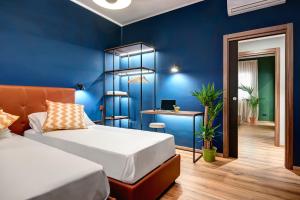 - une chambre avec un lit et un mur bleu dans l'établissement Carusotto - Sorrento, à Sorrente