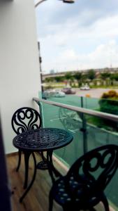 two chairs and a table on a balcony with a tennis court at Hotel Legend Boutique in Johor Bahru