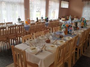 a long table in a room with tables and chairs at SILVER Zawoja in Zawoja
