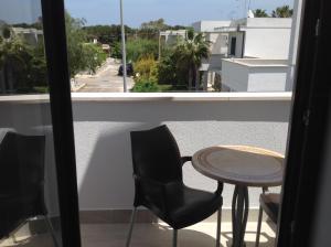 a balcony with a table and chairs and a window at Hotel Corallo in Torre Santa Sabina