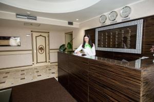 a woman standing at a counter in a room at Park Hotel Warshawskiy in Sarny