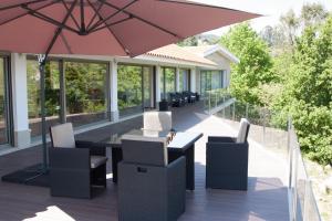 a patio with a table and chairs and an umbrella at Refúgio do Tâmega in Penafiel