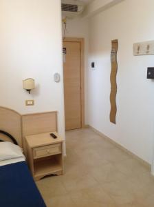 a bedroom with a bed and a wall with a sculpture at Hotel Corallo in Torre Santa Sabina