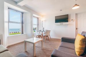 a living room with a couch and a table at Fiveway Apartments in Paignton