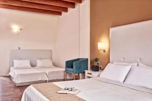 una habitación de hotel con 2 camas y una silla azul en All Senses Nautica Blue Exclusive Resort & Spa - All Inclusive en Fánai