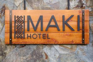 a sign for a hotel hanging on a stone wall at Maki Hotel in Pucón