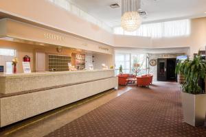 a lobby of a hotel with a reception counter and chairs at Leoso Hotel Leverkusen in Leverkusen