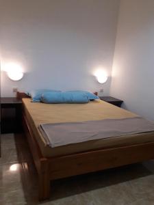 Puji Homestay في ماتارام: غرفة نوم بسرير ومخدات زرقاء ومصباحين