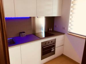 a small kitchen with white cabinets and a stove at Vacanze in Puglia Conversano in Conversano