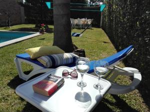 a table with wine glasses and a book on it at Casa do Sol - Entre o Mar e o Pinhal in Apúlia
