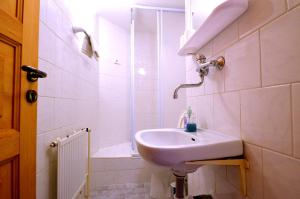 een witte badkamer met een wastafel en een douche bij Pension Centrum in Špindlerův Mlýn