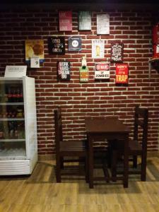 a table and chairs next to a brick wall with signs at Puji Homestay in Mataram