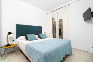 1 dormitorio con 1 cama grande con manta azul en Flatsforyou Ruzafa, en Valencia