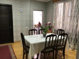 a dining room table with a vase of flowers on it at Kutaisi Grand Suites in Kutaisi +34 photos