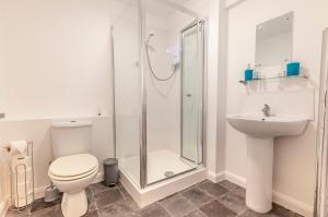 a bathroom with a shower and a toilet and a sink at Five Way Apartments in Paignton