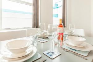 a white table with glasses and a bottle of wine at Five Way Apartments in Paignton