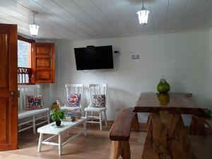 a living room with two chairs and a tv on the wall at Elizabetha Hostal in Salento