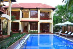 a villa with a swimming pool in front of a house at The Earth Villa in Hoi An