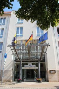 a hotel with flags on the front of it at Hotel Ascania in Aschersleben