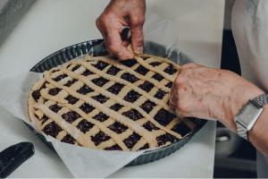 a person holding a pie in a pan at Hotel del Rio Srl - RISTORANTE e Azienda agricola in Casinalbo