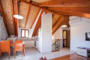a kitchen with wooden ceilings and a table and chairs at Apartments and Rooms Marino in Trogir