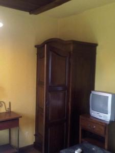 Cette chambre dispose d'une télévision et d'une armoire en bois. dans l'établissement Apartamento Rural El Oso 2, à Pola de Somiedo