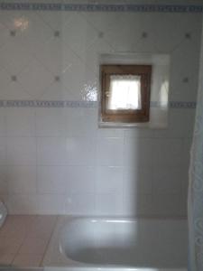La salle de bains est pourvue d'une baignoire et d'une fenêtre. dans l'établissement Apartamento Rural El Oso 2, à Pola de Somiedo