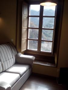 a living room with a couch and a large window at Apartamento Rural El Oso 2 in Pola de Somiedo