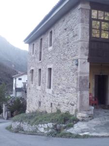 a stone building with a door on the side of it at Apartamento Rural El Oso 2 in Pola de Somiedo