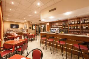 restauracja ze stołami i krzesłami oraz bar w obiekcie Hotel Tirreno w Genui